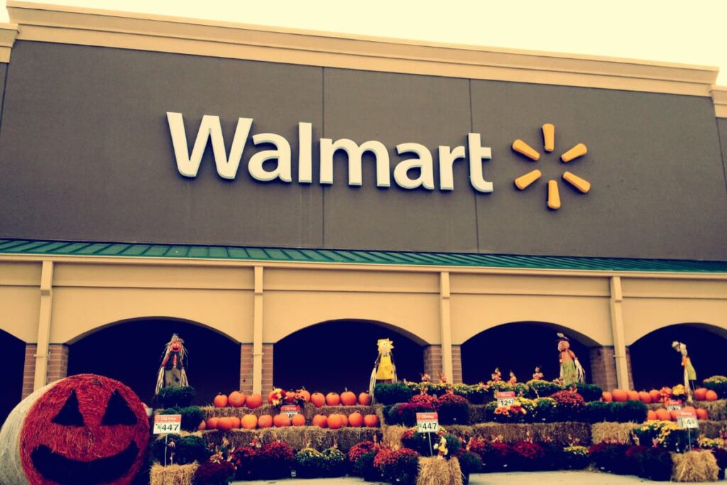 Walmart price matching policy at Walmart store and the store is decorated with one big size pumpkin and many small size pumpkins.