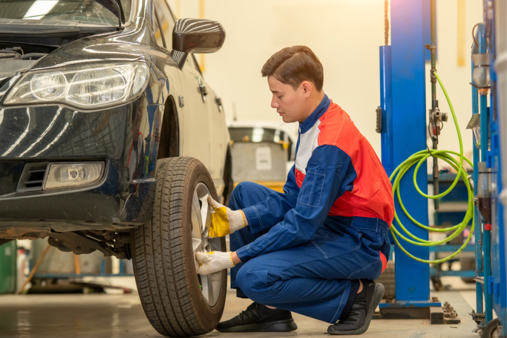 Red and blue uniform wearing a man install a tire to car at walmart auto care center.