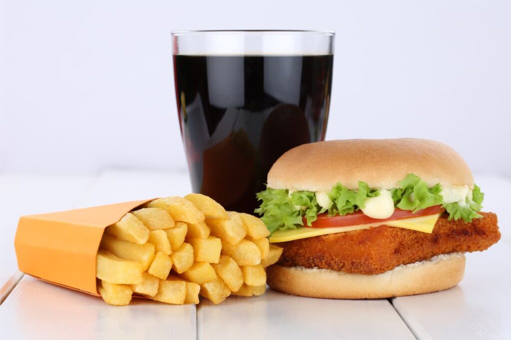Does Wendy's Have A $5 Special? - (What Is, What Comes, Worth It) burger with a Patti, slice of cheese, slice of tomato, mayonnaise and coriander in it - with a soft drink in a glass and bunch of French fries in a packet.