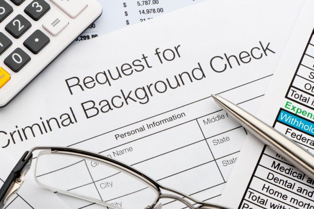 Criminal Background check by Walmart paper along with one Calculator, one Pen and one Spectacle Glasses.