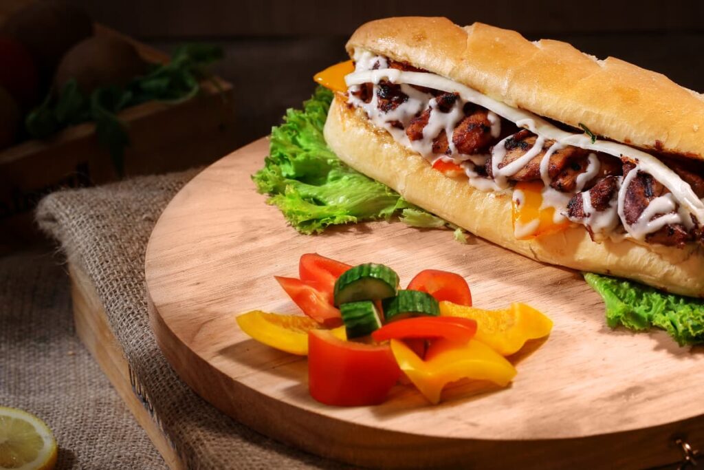Mcdonald's Free Sandwich is served with the wooden plate, and it is served with some cucumber, red and yellow capsicum pieces along with Lettuce.