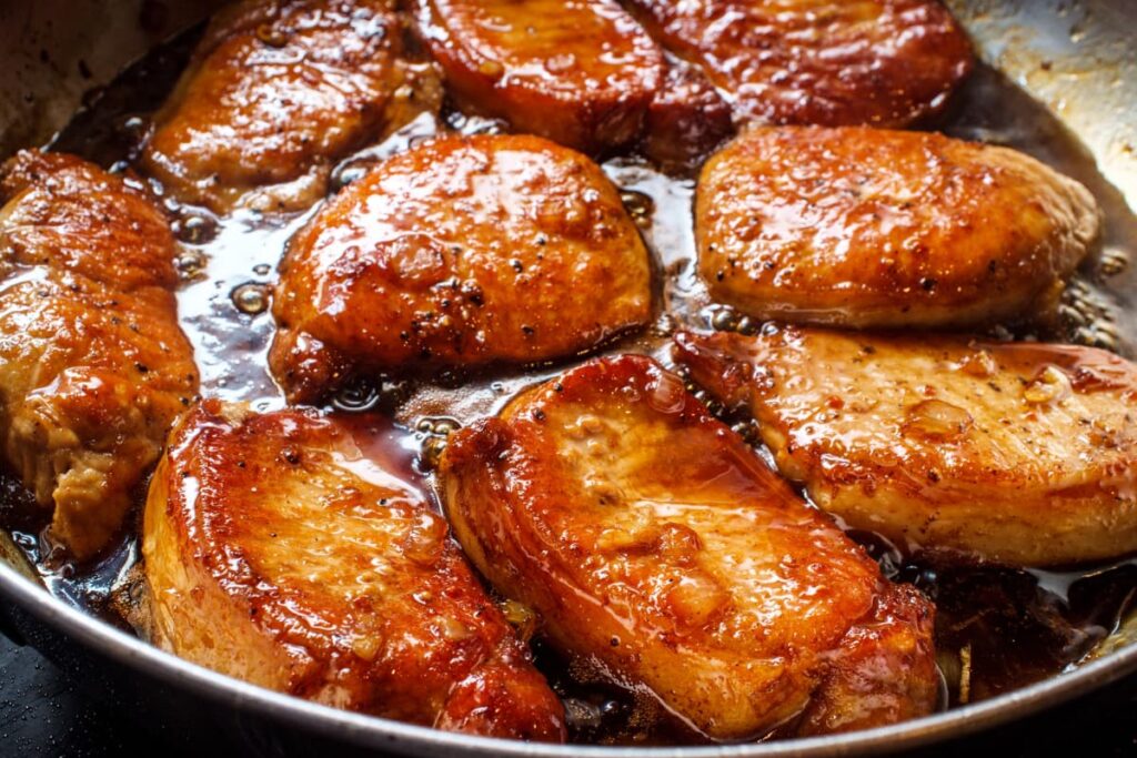 Chick-Fil-A Honey Roasted BBQ Sauce used in chicken. Chick fil a honey roasted BBQ sauce mixed with chicken in a large steel plate.