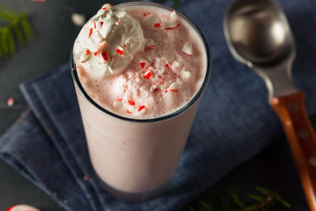 Chick Fil A Peppermint Milkshakes serves in a glass along with the spoon. Chick Fil A peppermint milkshake contains peppermint, milk, ice cream and milkshake is garnished with peppermint.