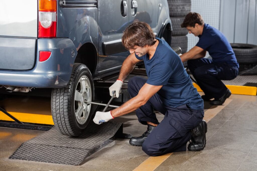 Walmart Fix Flat Tires by two technicians while fixing tires to a car with the help of tire fixing tool. 