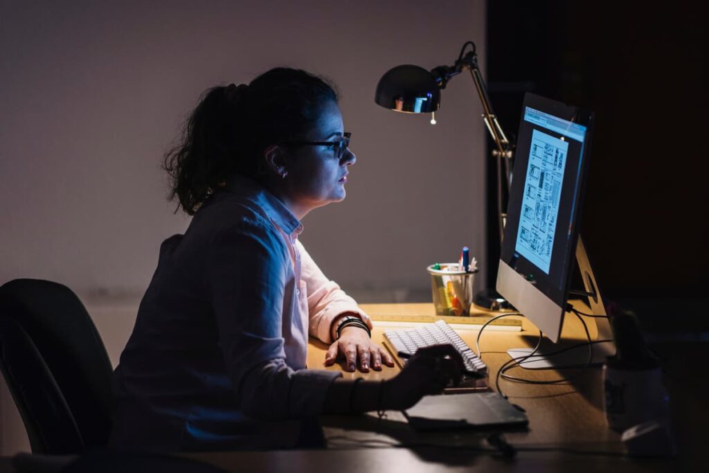 Walmart Night Shift Job done by a women in front of her desktop and sitting in a chair along with lamp light, pen holder.