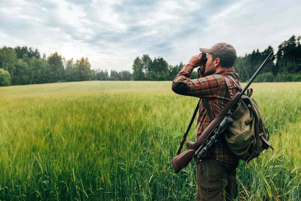 With Walmart Hunting License a man used to hunt with one gun in a green grass fields.