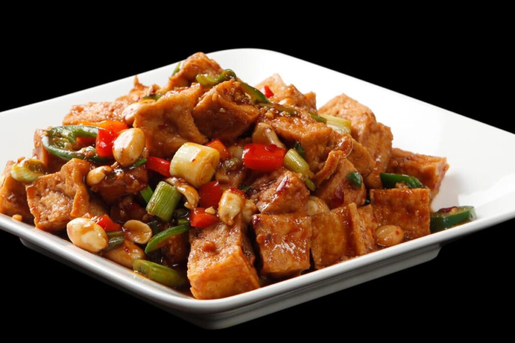 Walmart Tofu served with red bell pepper, capsicum, spring onions, tomato sauce in a white serving tray.