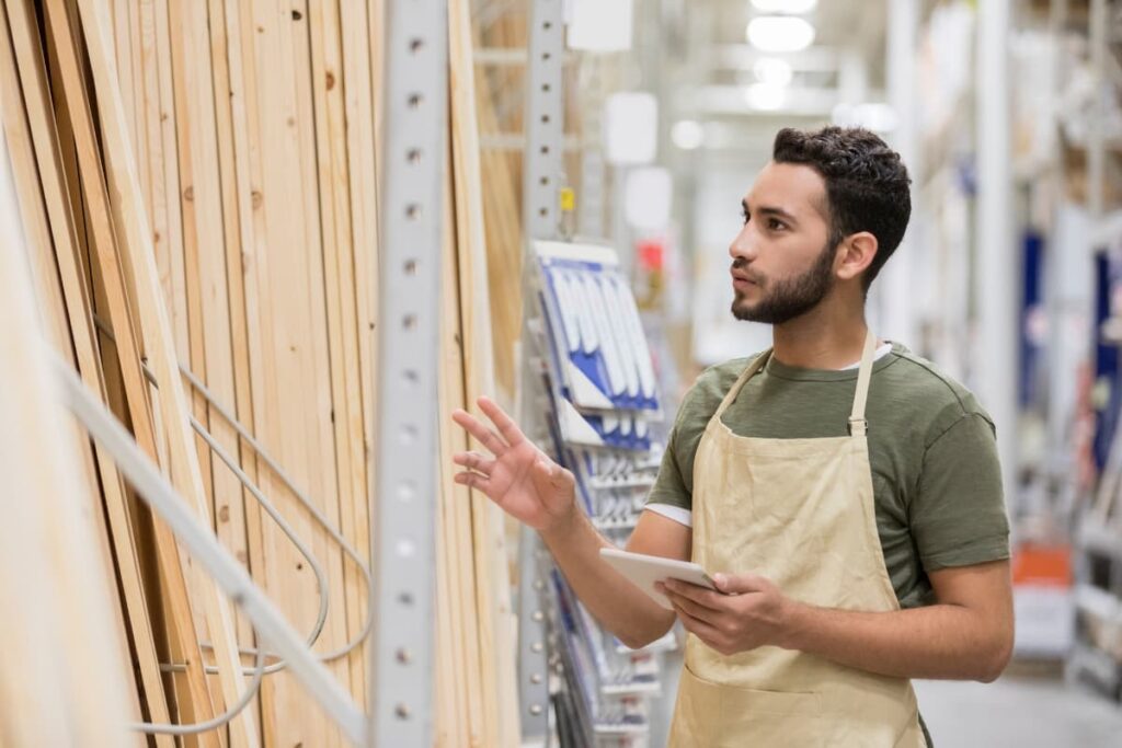 An associate at Lowe's is making sure of products are of in correct order in their store.