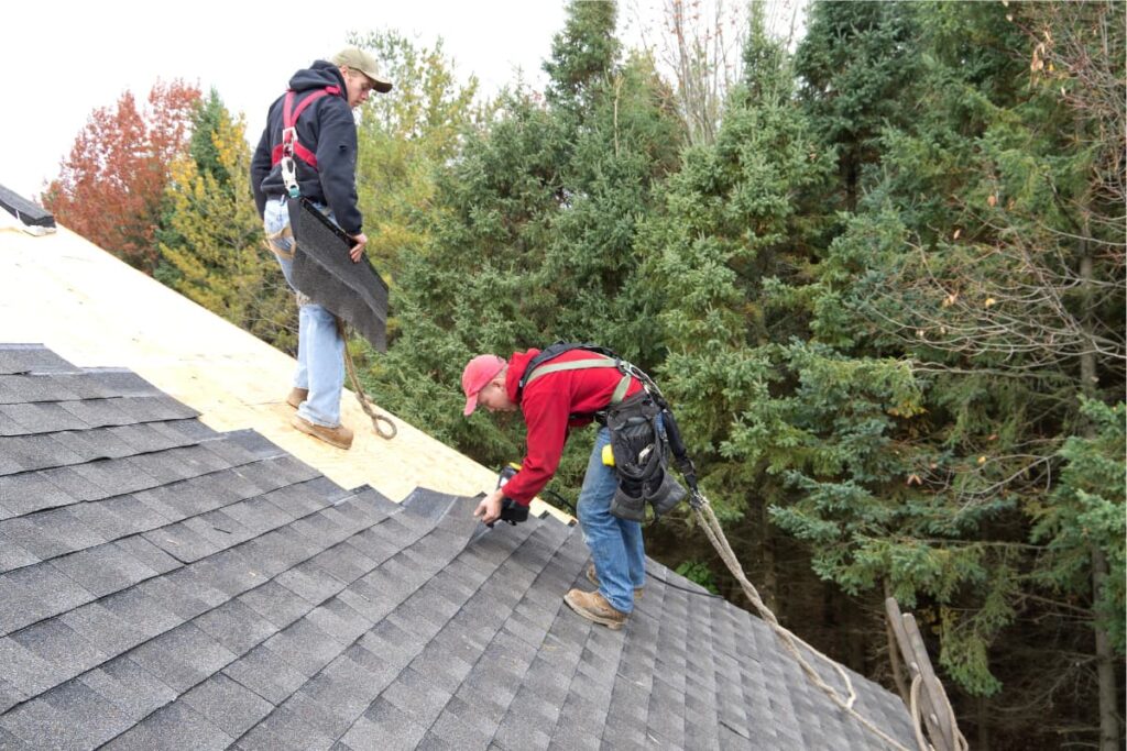 Lowe's Shingles has been placing on the roof by an associate and the other person standing in front by having Lowe's Shingles in his hand.