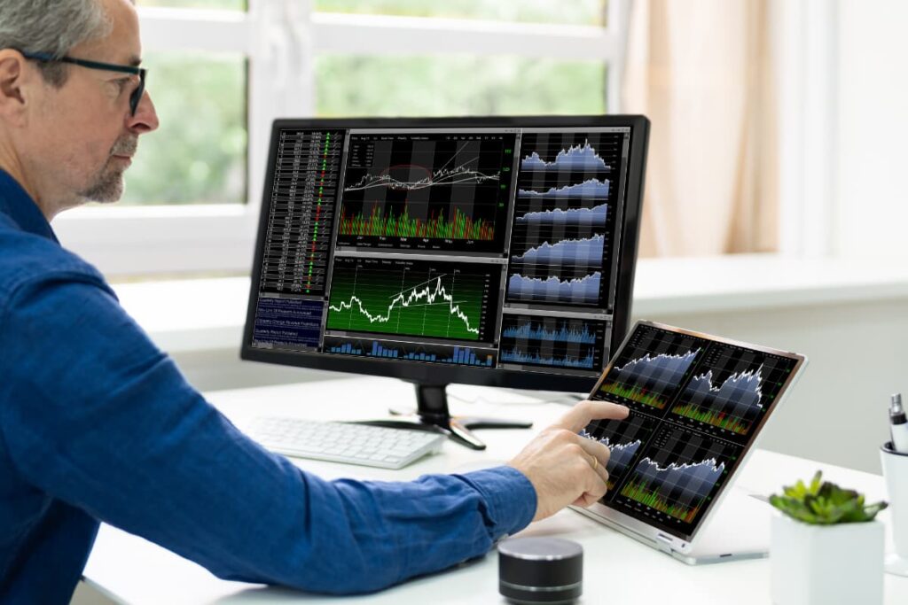 Walmart Stocks value monitored by a person in his Desktop and Laptop on a white table.