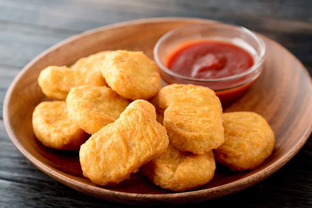 Chick Fil A Nuggets can be served in a brown color plate. It has plate of fried chicken nuggets along with the ketchup which is placed in a small cup beside the nuggets.