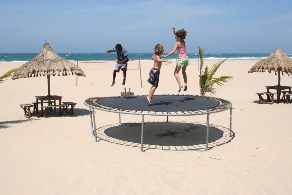 Walmart Trampolines were placed near beach view where three kids are playing on Trampoline. 