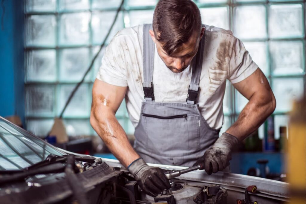 Walmart Automotive Technician testing vehicle conditions with the help of repairing tools and wearing gloves. 