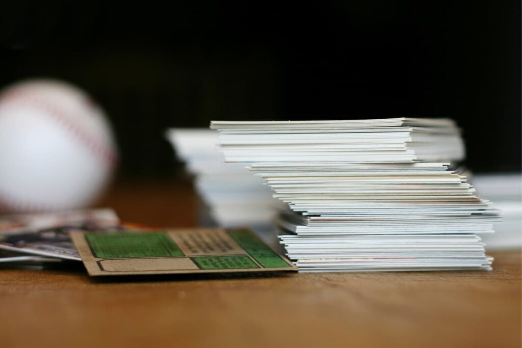 Walmart Baseball Cards placed on a wooden tables along with one white base ball.