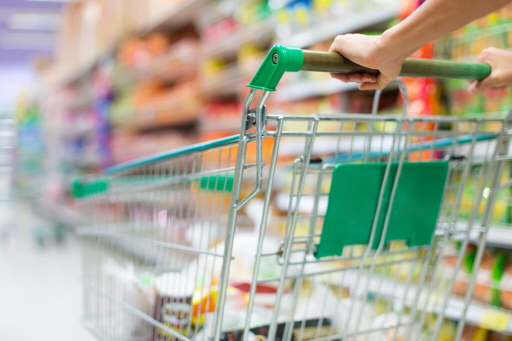 Cart Pusher at Walmart Store pushing the cart contains vegetables, fruits and other grocery items at the store.