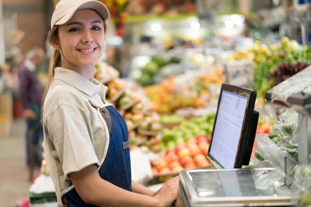 Walmart Cashier checking receipts at the counter near the fruits and vegetable store.