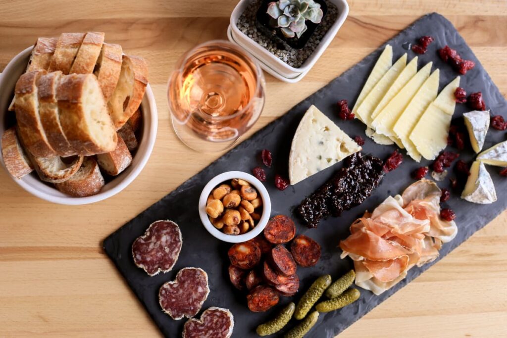 Walmart Deli served with fresh breads, sweet wines, chesses slices, kulen, charcuterie on a wooden table.