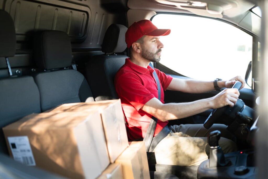 Delivery Driver at Walmart with red cap and red t shirt loaded boxes in a car.