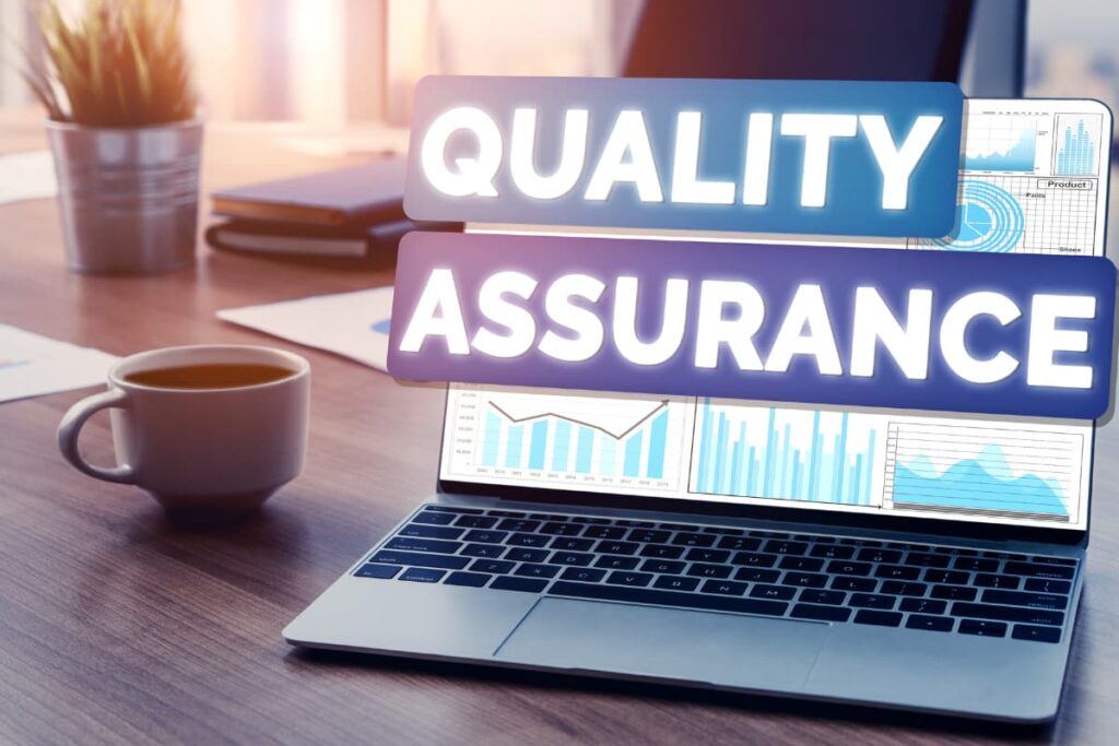 Walmart Quality Assurance Job reading comments through Laptop along with cup of a coffee, books, flower pot on a wooden table.