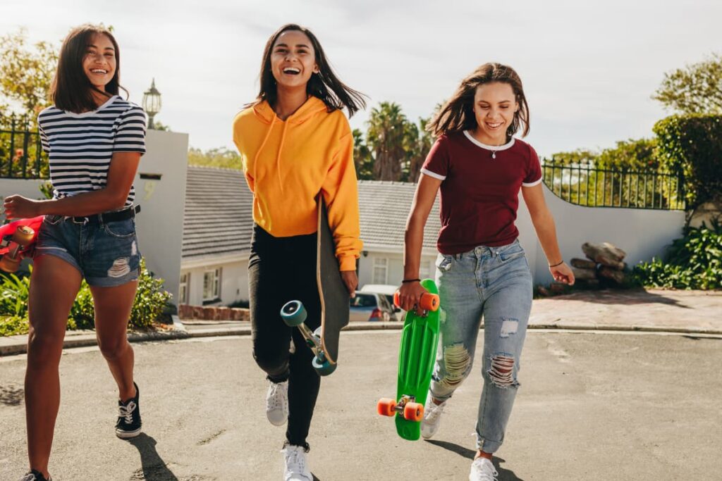 Walmart Skateboards in a colors of green, black red played by three teenage girls in a parking place.  