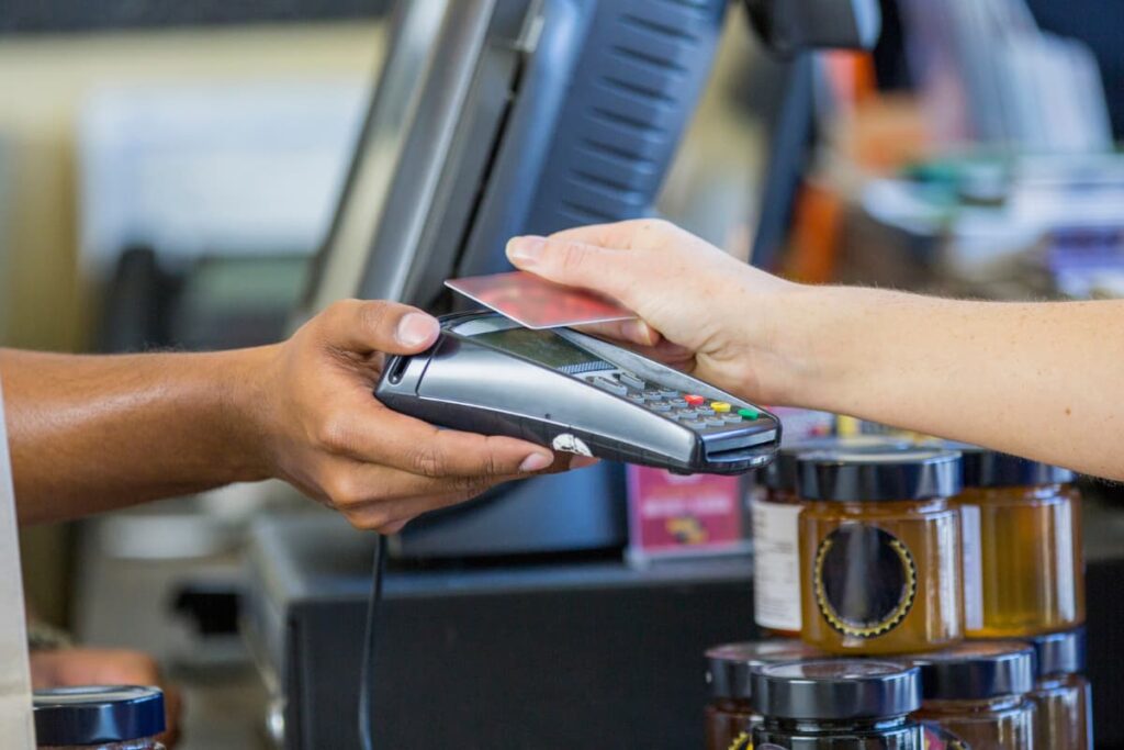 A person using Walmart Tap To Pay payment method at Walmart counter.
