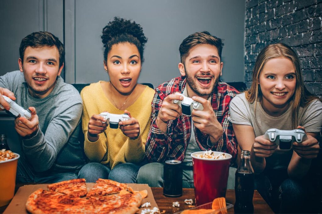 Walmart Xbox One console used to play games by four friends while enjoying their free time with popcorn, pizza and Coke on a Wooden Table.