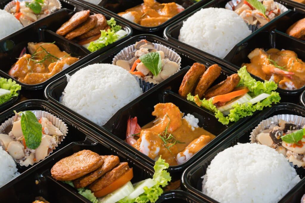 Walmart eMeals contains a rice, lattice, chicken pieces and vegetable salad on a partition tray.