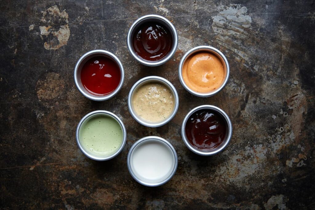 Chick Fil A Sauces are available in different flavors with different taste. Here there are 7 different sauces are placed in small alluminium cups, which are different colors(white, orange, creamy, white, red, green and brown)