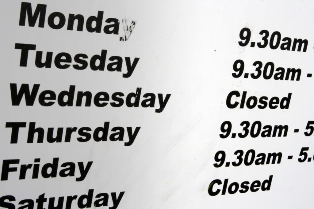 Chick Fil A Opening timings are displayed on a white board. In white board they mention the opening timings on each of the day(monday, tuesday, wednesday, thursday, friday, saturday) in black color.