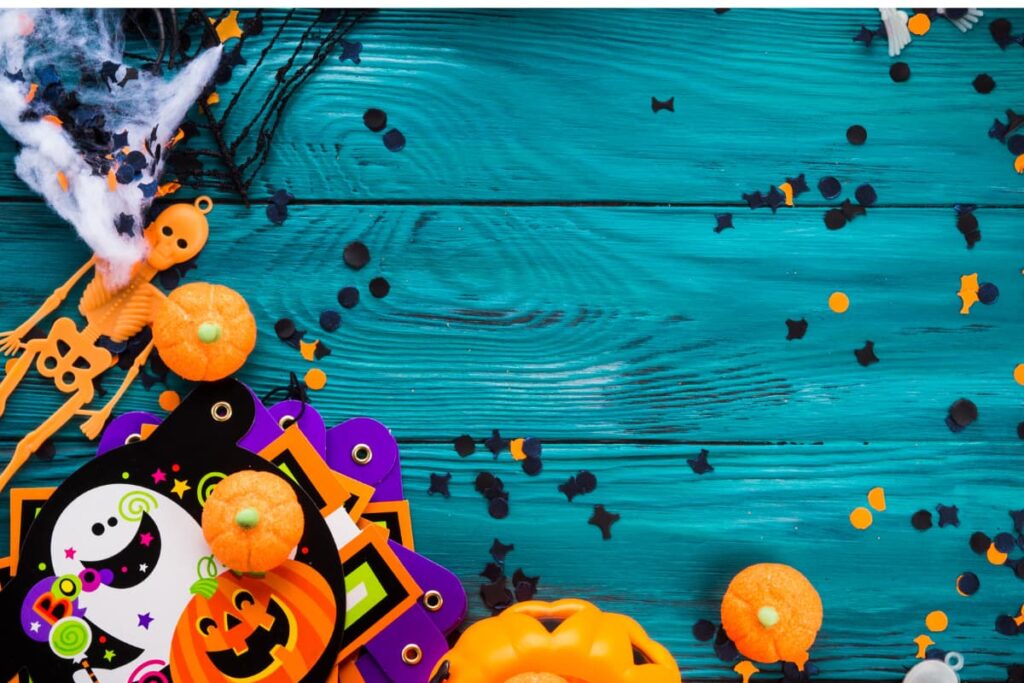 Walmart Halloween Stuff includes decoration items like pumpkins, skeleton ornament, vampire's paper cutout and three mini pumpkins on a blue spark lucida wooden table.