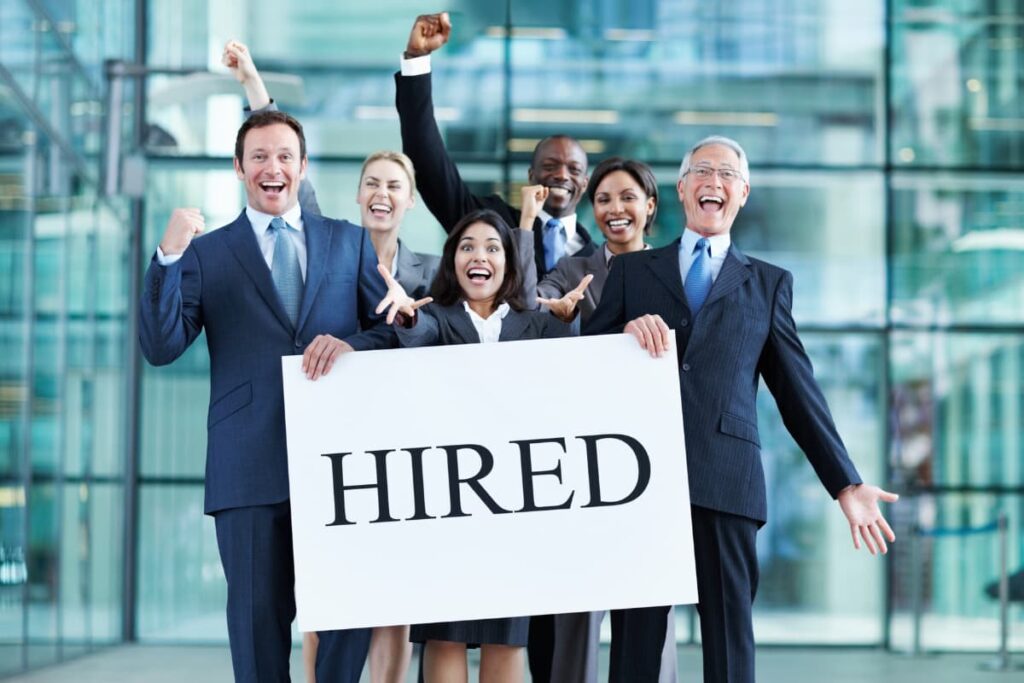 Starbucks Hired poster holds 6 members, which is white in color and Hired is written in black color. Hired poster holds 2 men and the other 4 are raises their left hands. 