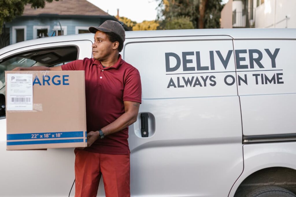 Instacart delivery Service at Publix by a delivery person holding large products box into a truck.
